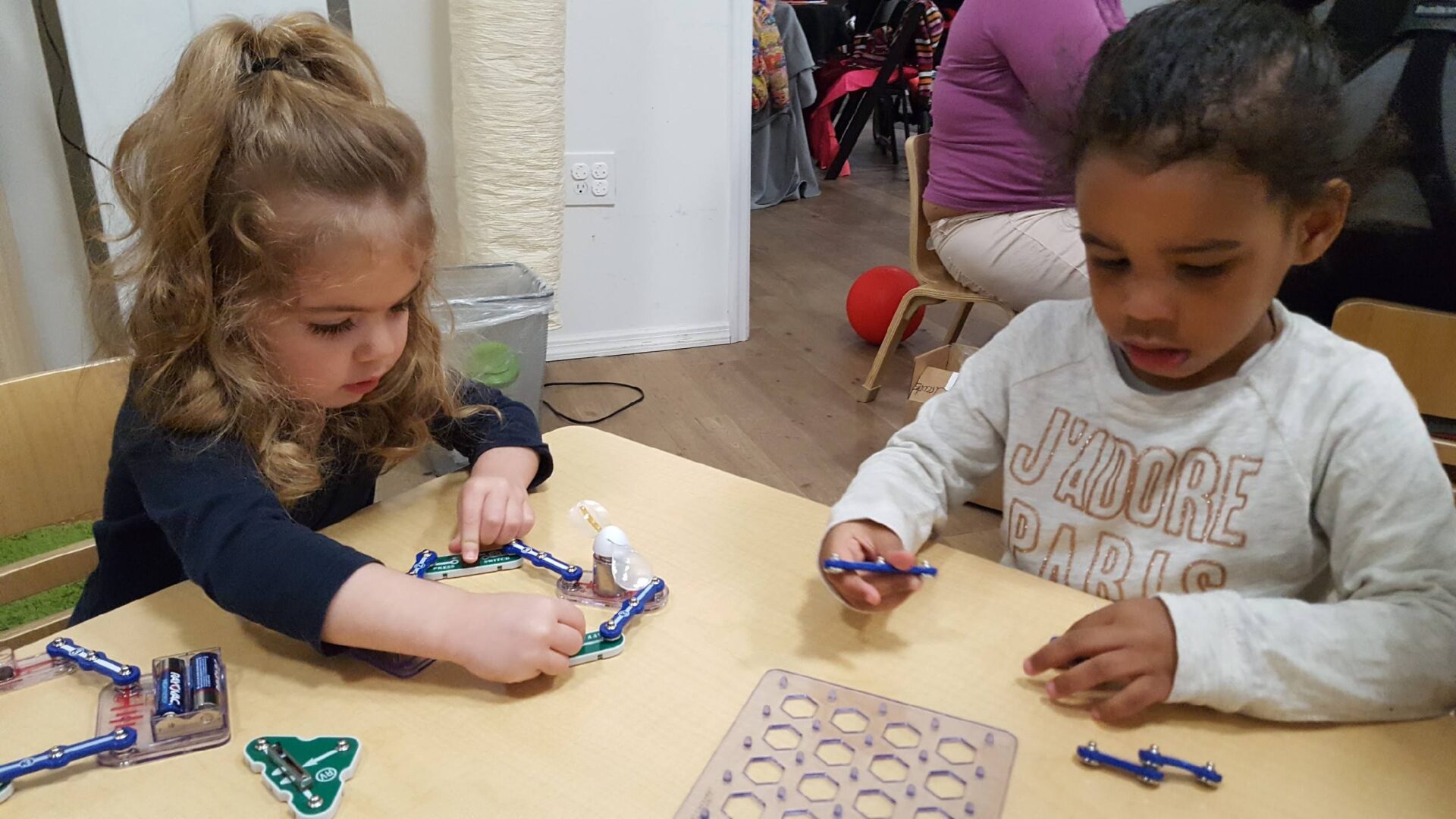 Two children are playing with a game on the table.