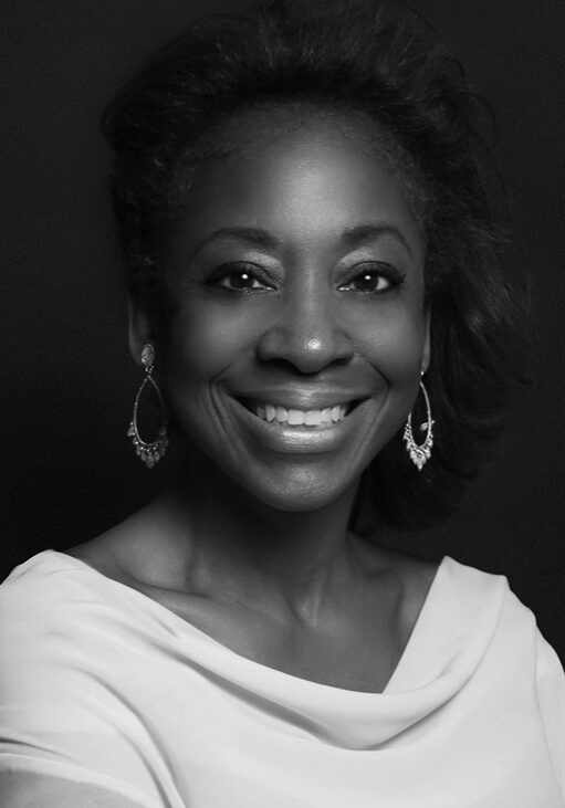 A black and white photo of a woman smiling.